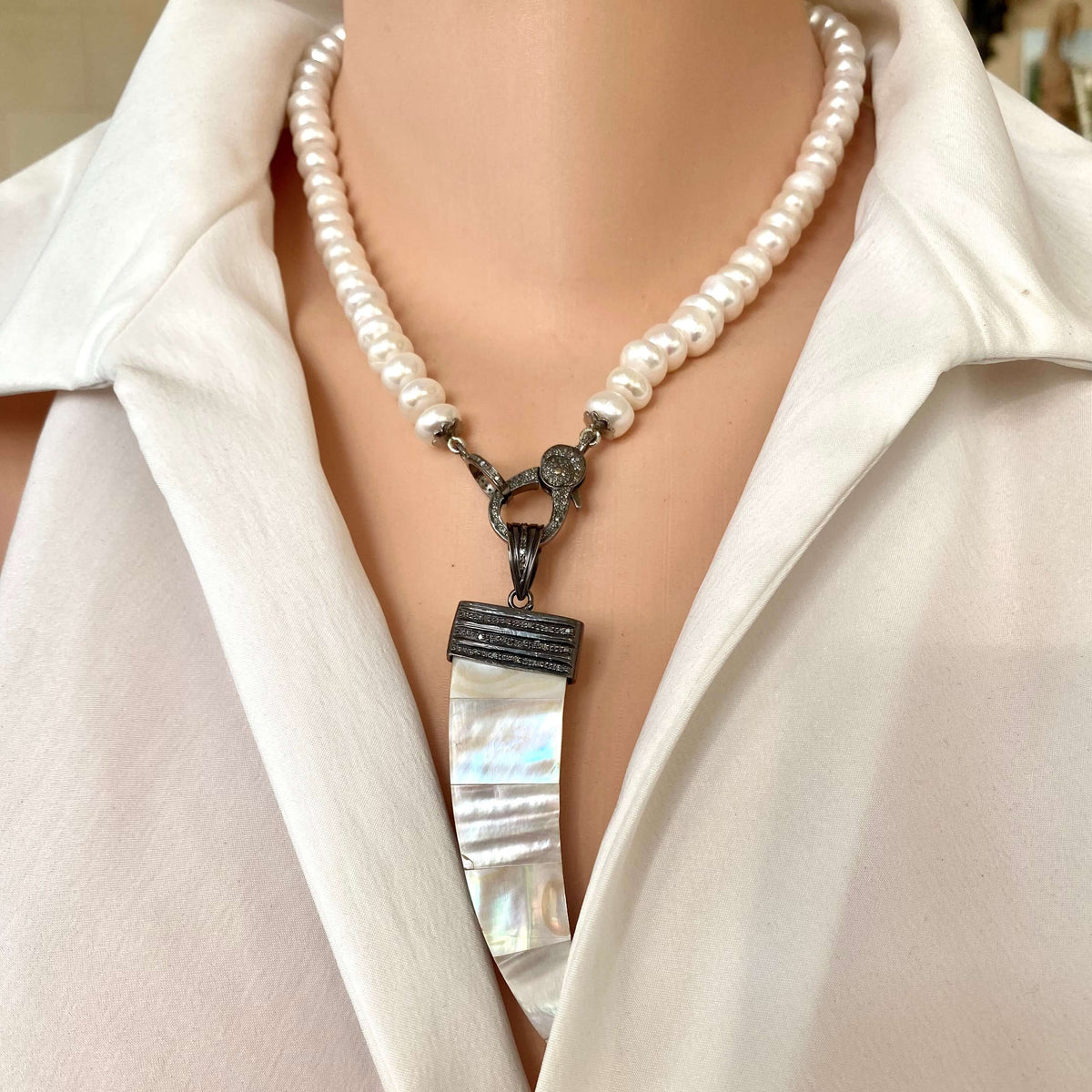 Button pearl necklace with diamond pavé styled with a removable pendant on oxidized silver clasp