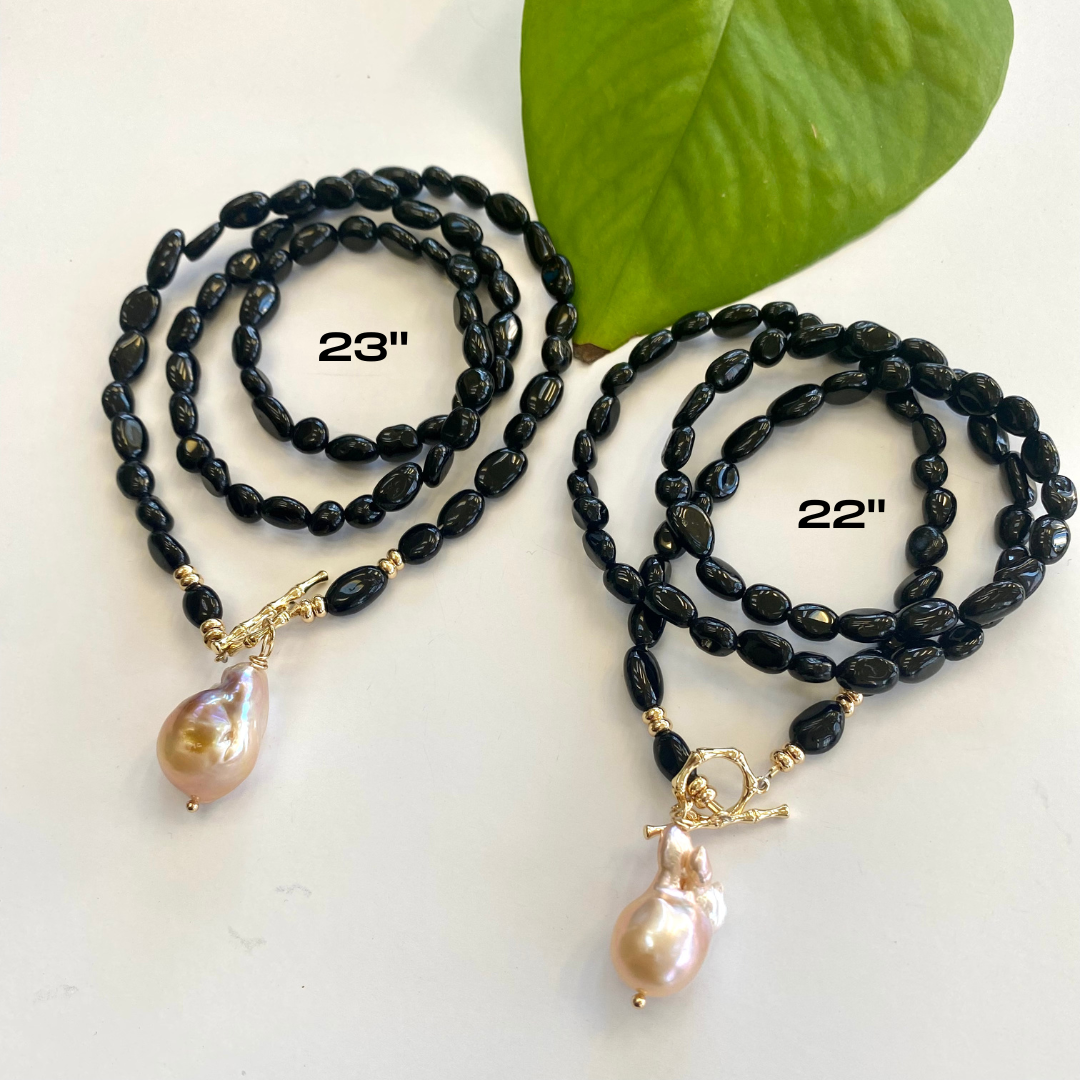 Black tourmaline pearl necklace in longer length displayed on white cloth