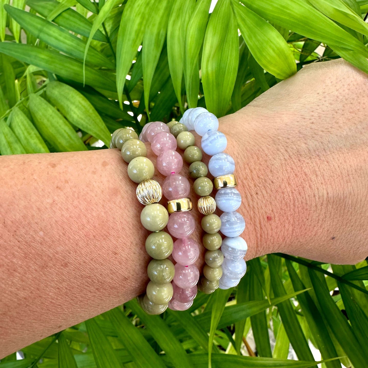 Green Olivine Jasper Bracelet stacked with other bracelets on wrist – natural foliage shot