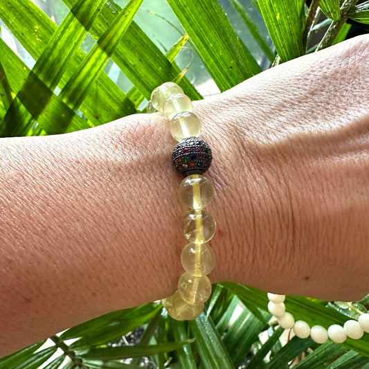 Lemon Quartz Bracelet worn on model’s wrist against green foliage – lifestyle shot