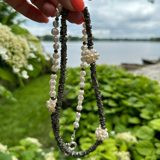 Close up of pyrite and pearl necklace outdoors with greenery