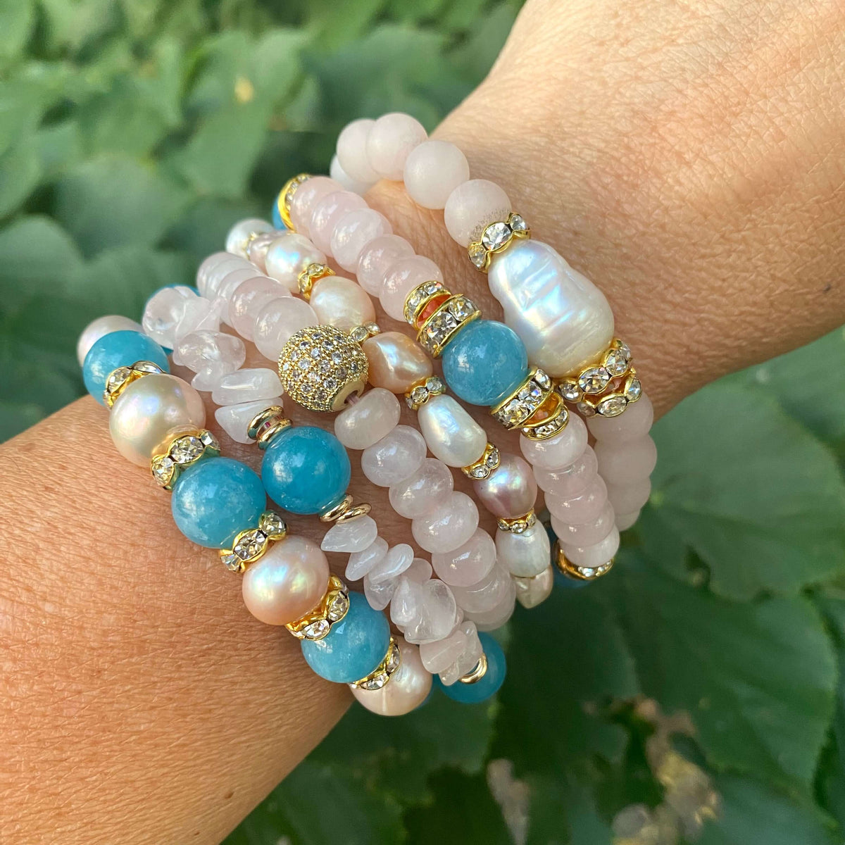 Blue sponge rose quartz pearl stretchy bracelet styled stacked on wrist with soft pastel tones