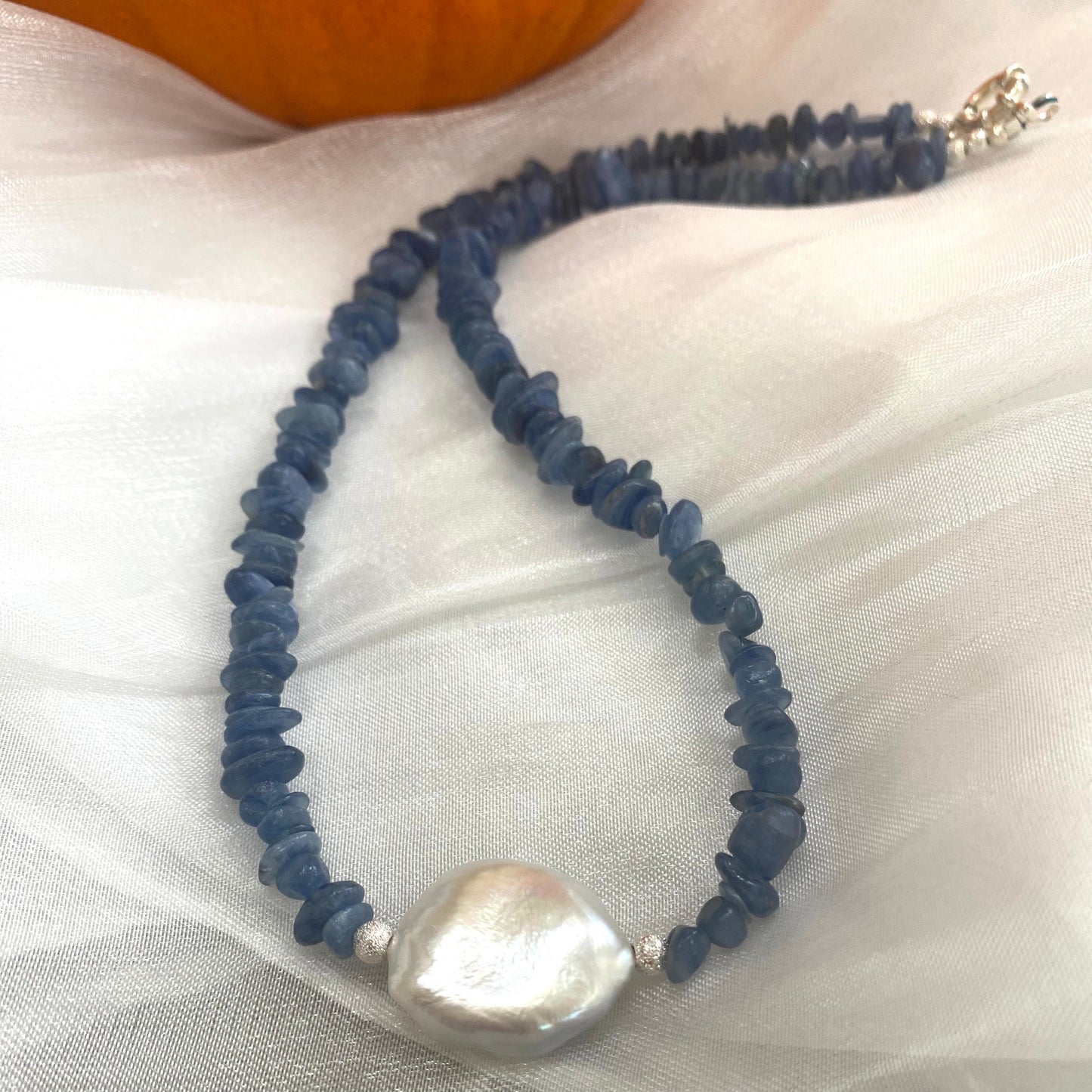 Blue kyanite pearl necklace displayed on white cloth
