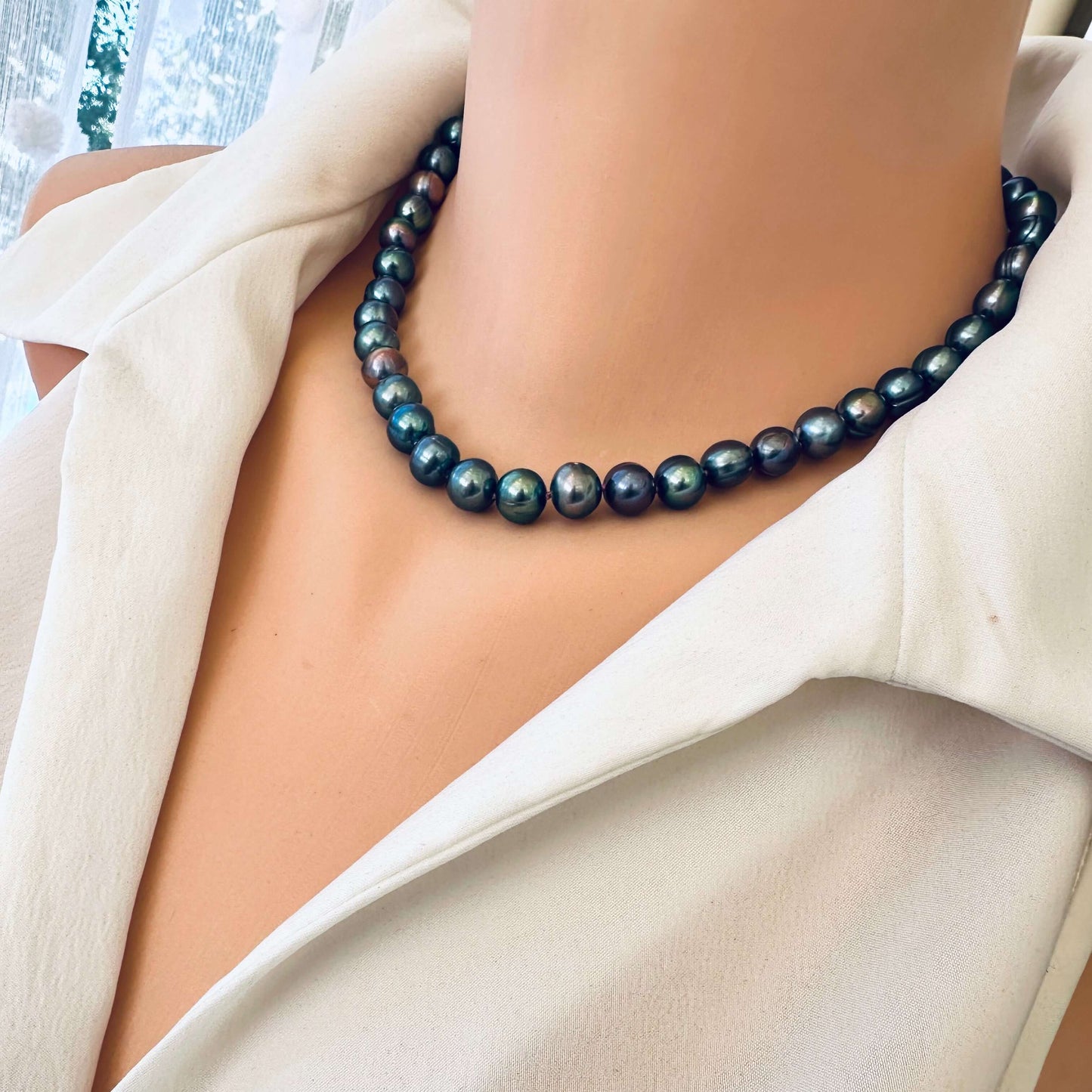 Side close up of peacock pearl necklace worn on mannequin