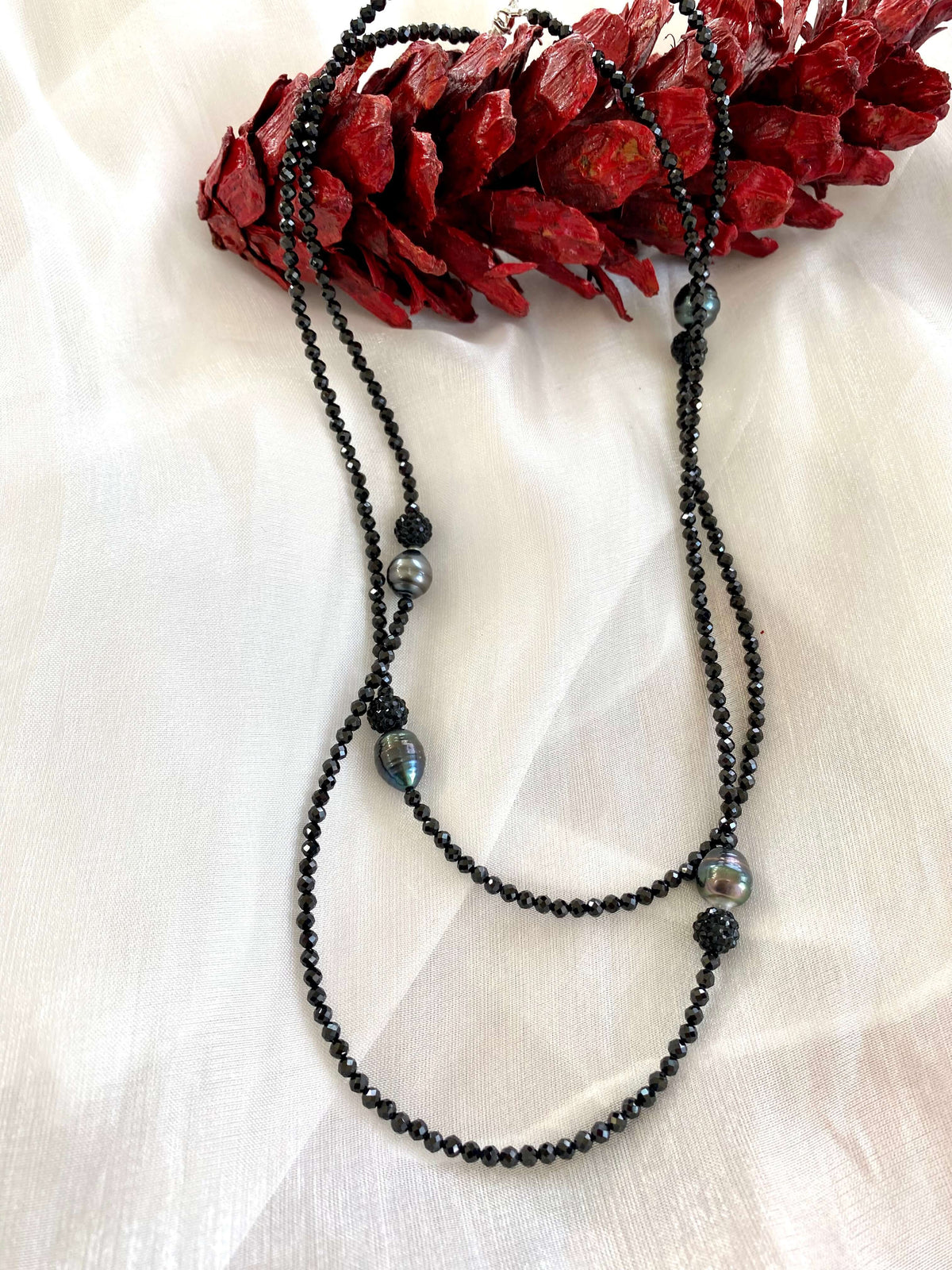 Black spinel pearl necklace on mannequin, close-up gemstone view