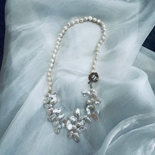 Carica l'immagine nel visualizzatore di Gallery, Add a touch of organic elegance to your look with this stunning 25" white Keshi pearls necklace, featuring a unique asymmetrical design that showcases both petal-shaped and nugget pearls.
At the side, a beautiful golden palm leaf toggle clasp adds a tropical flair