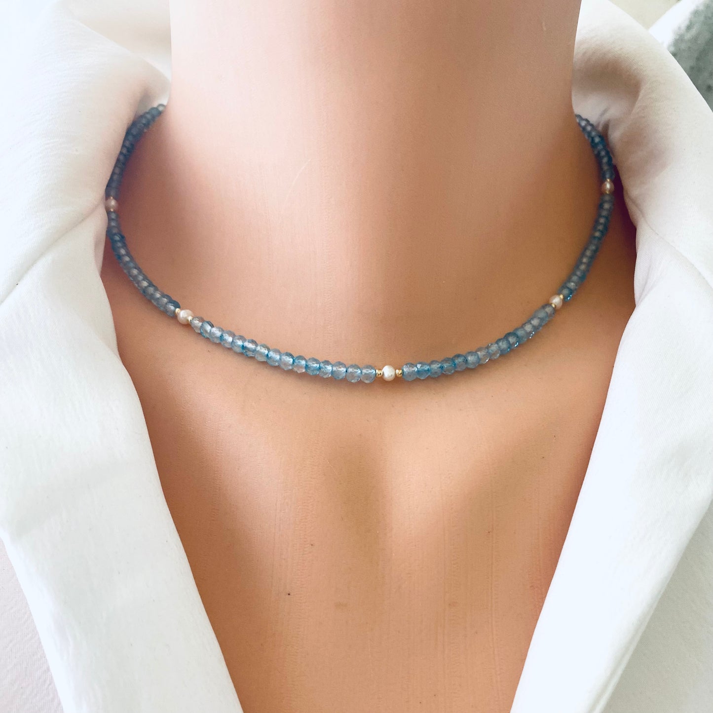 Blue topaz pearl choker necklace on mannequin, close-up detail