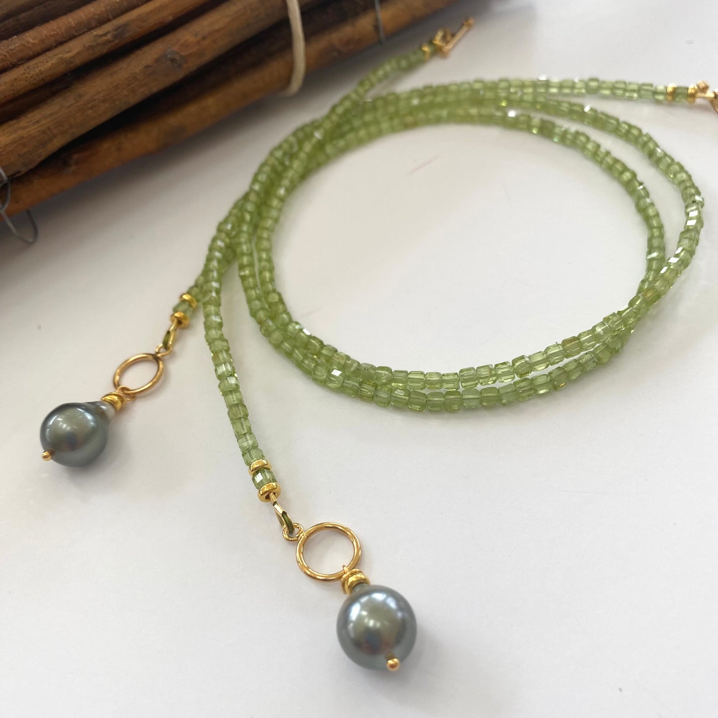Peridot baroque pearl necklace featuring vibrant green Peridot beads and Tahitian Baroque pearl pendant in a toggle design.