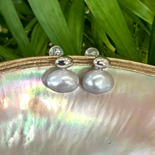 Load image into Gallery viewer, Silver grey nugget pearl stud earrings hanging from pearl shell with green leaf backdrop, handcrafted in Canada.