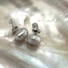 Load image into Gallery viewer, Silver grey nugget pearl stud earrings displayed on white pearl shell, designed and handmade in Canada.