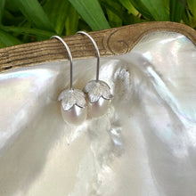 Cargar imagen en el visor de la galería, Rice Pearl Earrings – silver design displayed on pearl shell with green leaves