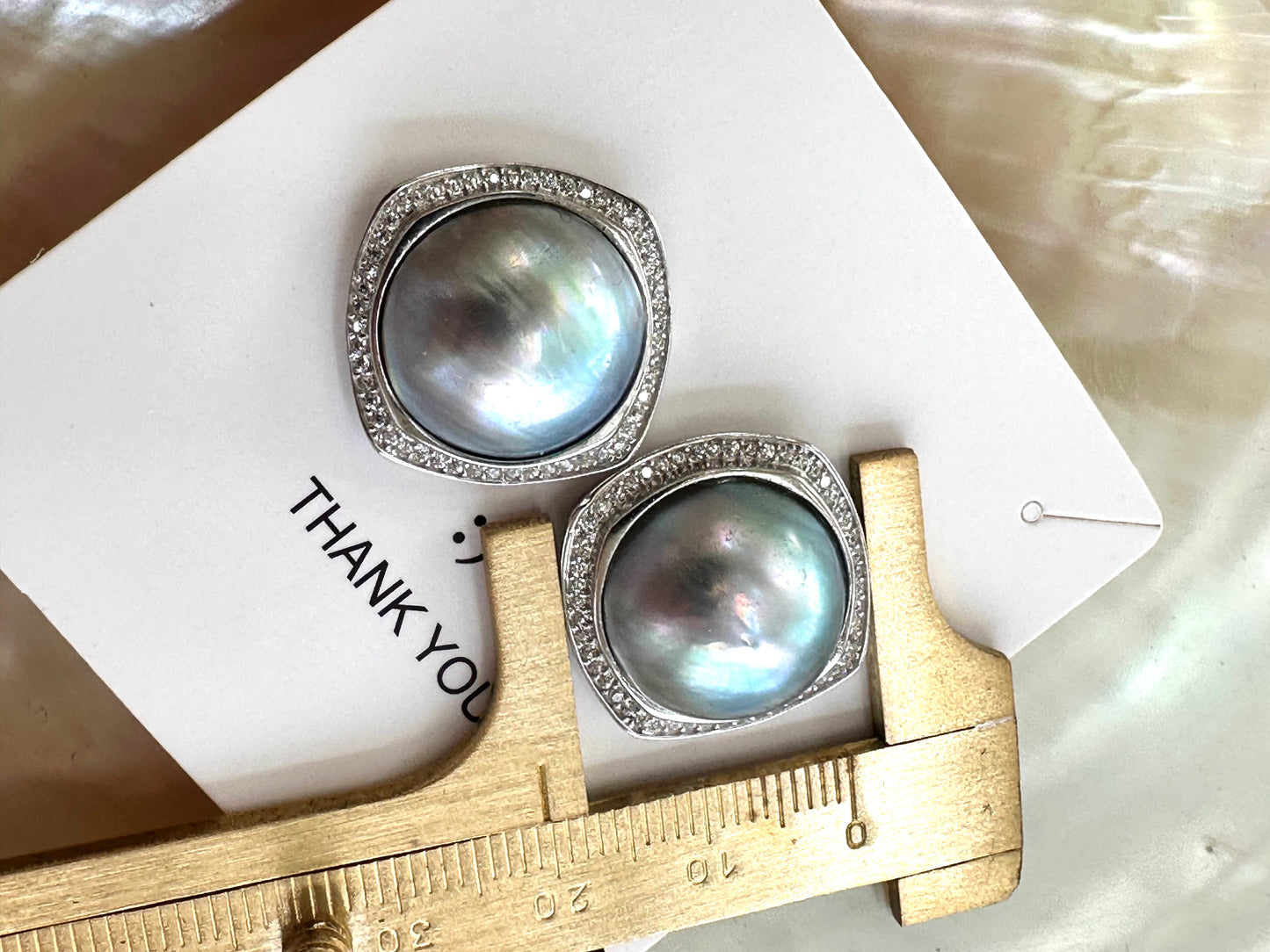 Mabe Pearl Earrings – close-up with one earring measured against ruler for size