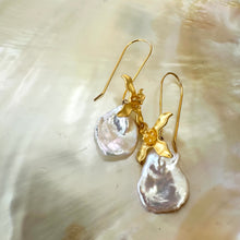 Carica l'immagine nel visualizzatore di Gallery, Elegant white Keshi Pearl Earrings with gold vermeil flower hooks resting on pearl shell background.