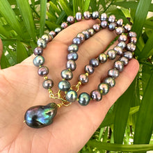 Charger l'image dans la galerie, Black pearl pendant necklace held in hand for scale against green leaf background