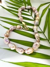 Carica l'immagine nel visualizzatore di Gallery, Close view of golden pink baroque pearl necklace against green leaf backdrop