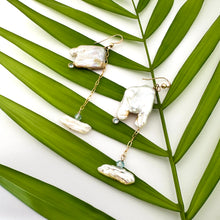 Lade das Bild in den Galerie-Viewer, Boho pearl earrings gold filled held against leafy green background — handcrafted square pearl earrings with blue accent by Loulia Pearl Jewelry