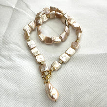 Carica l'immagine nel visualizzatore di Gallery, Full view of golden baroque pearl toggle necklace on white backdrop — handcrafted statement jewelry featuring square pearls and gold clasp