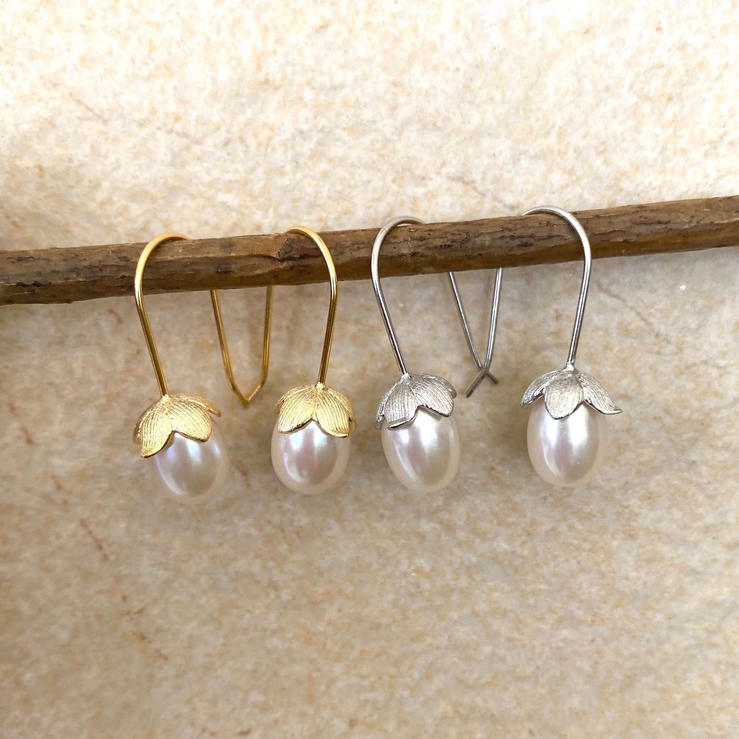 Rice Pearl Earrings – gold and silver sets side by side on branch and white background