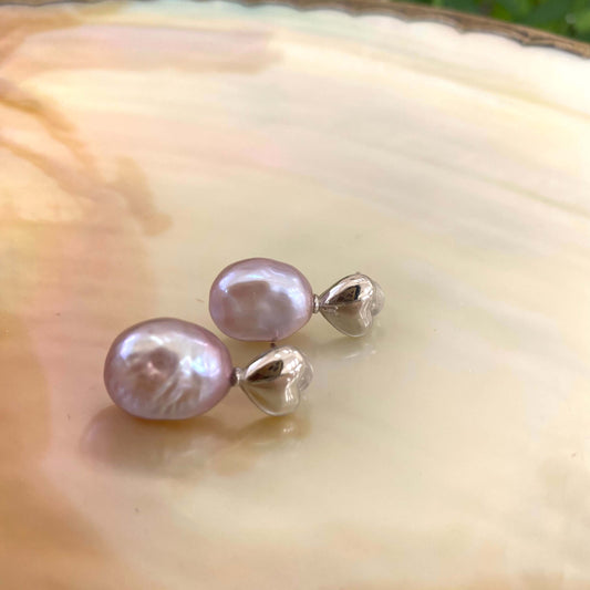 Heart Pearl Earrings – silver close-up against white pearl shell backdrop