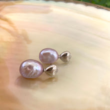 Cargar imagen en el visor de la galería, Heart Pearl Earrings – silver close-up against white pearl shell backdrop