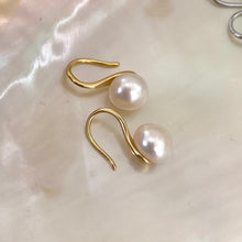 Carica l'immagine nel visualizzatore di Gallery, Button Pearl Earrings – gold version close-up displayed on white pearl shell