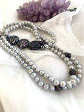 Carica l'immagine nel visualizzatore di Gallery, Double-strand Grey Pearl Necklace showcasing freshwater pearls and CZ embellishments beside amethyst on white cloth.