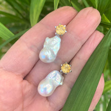 Lade das Bild in den Galerie-Viewer, Citrine stud earrings with pearl drops held in hand against green leaf background