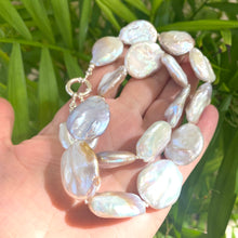 Cargar imagen en el visor de la galería, Close view of large coin pearl necklace with natural pearls on leaf backdrop