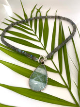 Load image into Gallery viewer, Labradorite aquamarine pendant necklace displayed on leafy branch backdrop — natural light gemstone jewelry by Loulia Pearl Jewelry