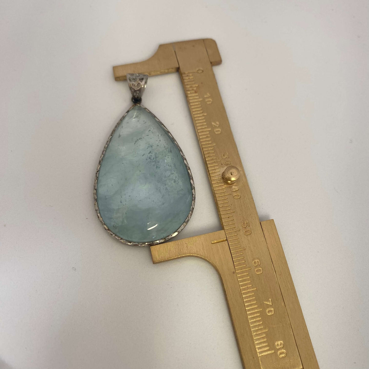 Labradorite aquamarine pendant necklace aquamarine gemstone pendant measured against ruler — size reference for handcrafted jewelry by Loulia Pearl Jewelry
