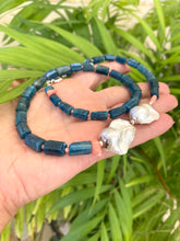 Charger l'image dans la galerie, Blue apatite coral pearl necklace held in hand against leafy green backdrop — colorful handcrafted gemstone jewelry by Loulia Pearl Jewelry