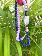 Lade das Bild in den Galerie-Viewer, Lapis lazuli and baroque pearl necklace displayed against green leaf backdrop, handcrafted gemstone jewelry.
