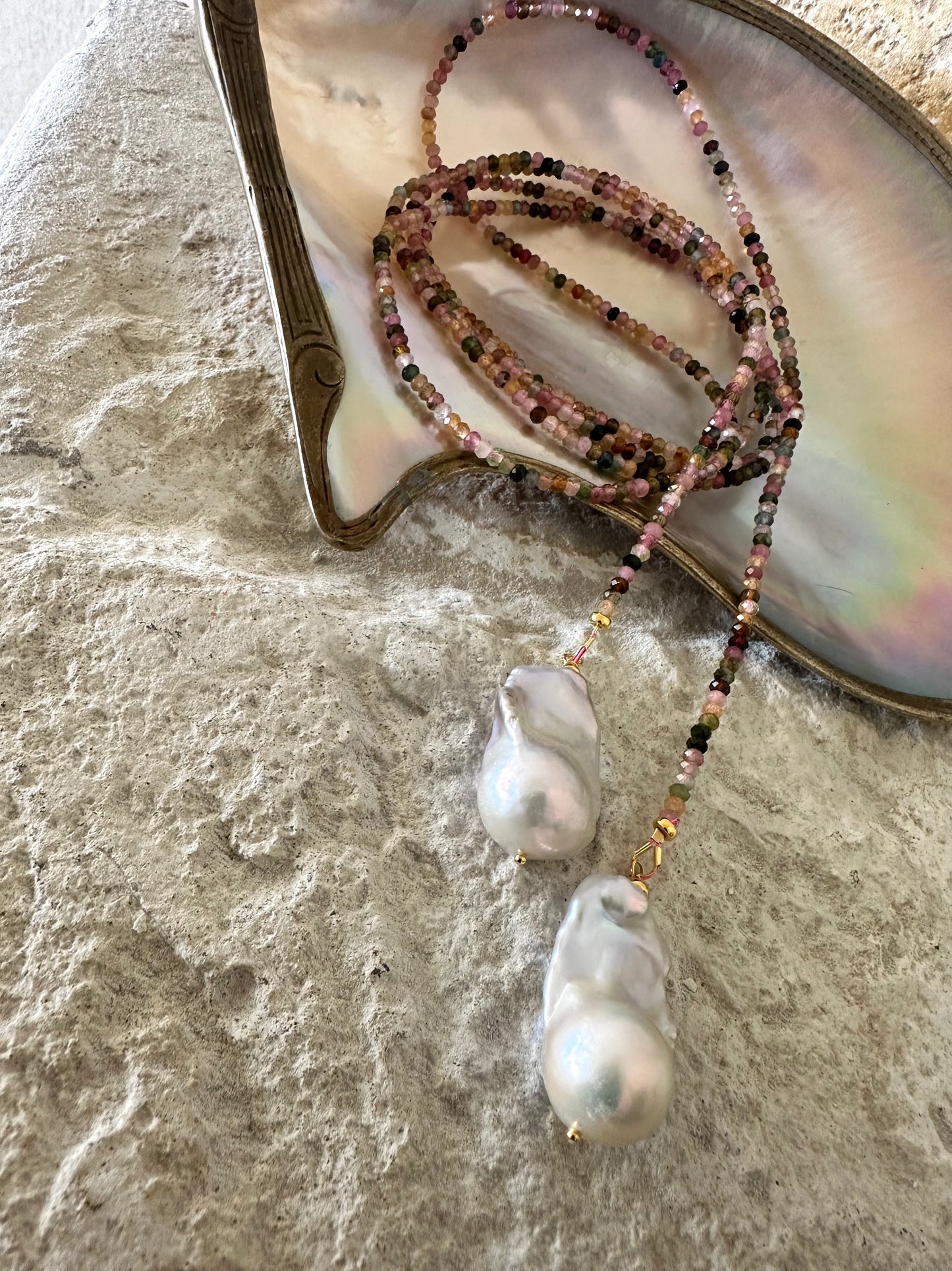 Close-up of Multi Tourmaline Baroque Pearl Lariat Necklace on white shell backdrop — colorful tourmaline and baroque pearls by Loulia Pearl Jewelry