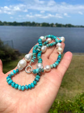 Cargar imagen en el visor de la galería, Arizona turquoise pearl necklace shown in hand beside a lake, featuring turquoise rondelle beads and large pearls.