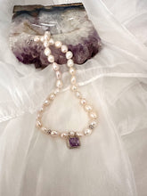 Cargar imagen en el visor de la galería, White Nugget Pearl Necklace with Amethyst Pendant – 'Viola' Collection on a soft fabric background.