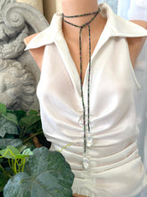 Lade das Bild in den Galerie-Viewer, Ruby Zoisite Baroque Pearl Necklace displayed on a mannequin in a stylish lariat design with greenery in the background.