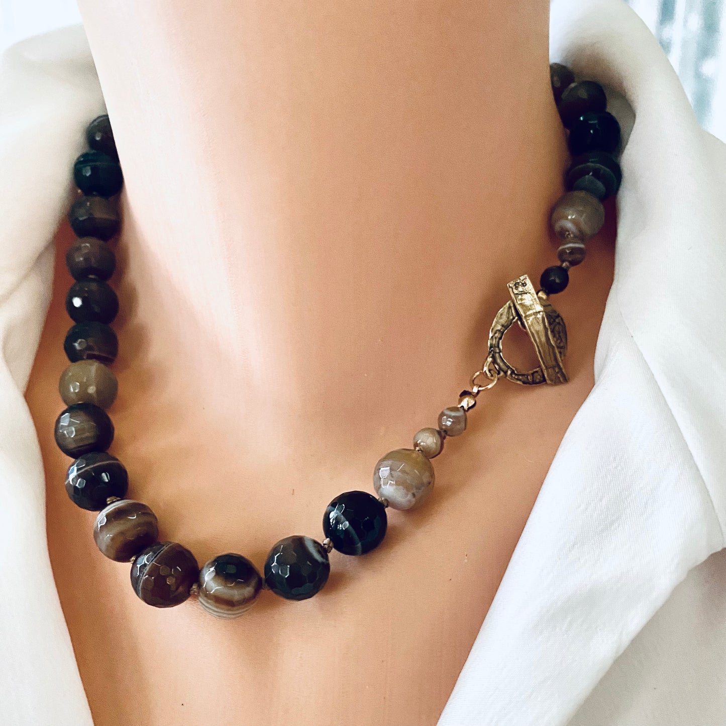 Botswana agate candy necklace with gold bronze details showcasing earthy hues and artisan craftsmanship.