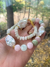 Cargar imagen en el visor de la galería, Detailed view of handmade morganite and jade necklace with baroque pearls held outdoors, highlighting pastel gemstone tones.