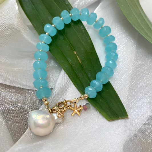 Chalcedony bracelet with starfish and baroque pearl charm, featuring faceted aqua blue beads on a soft background.