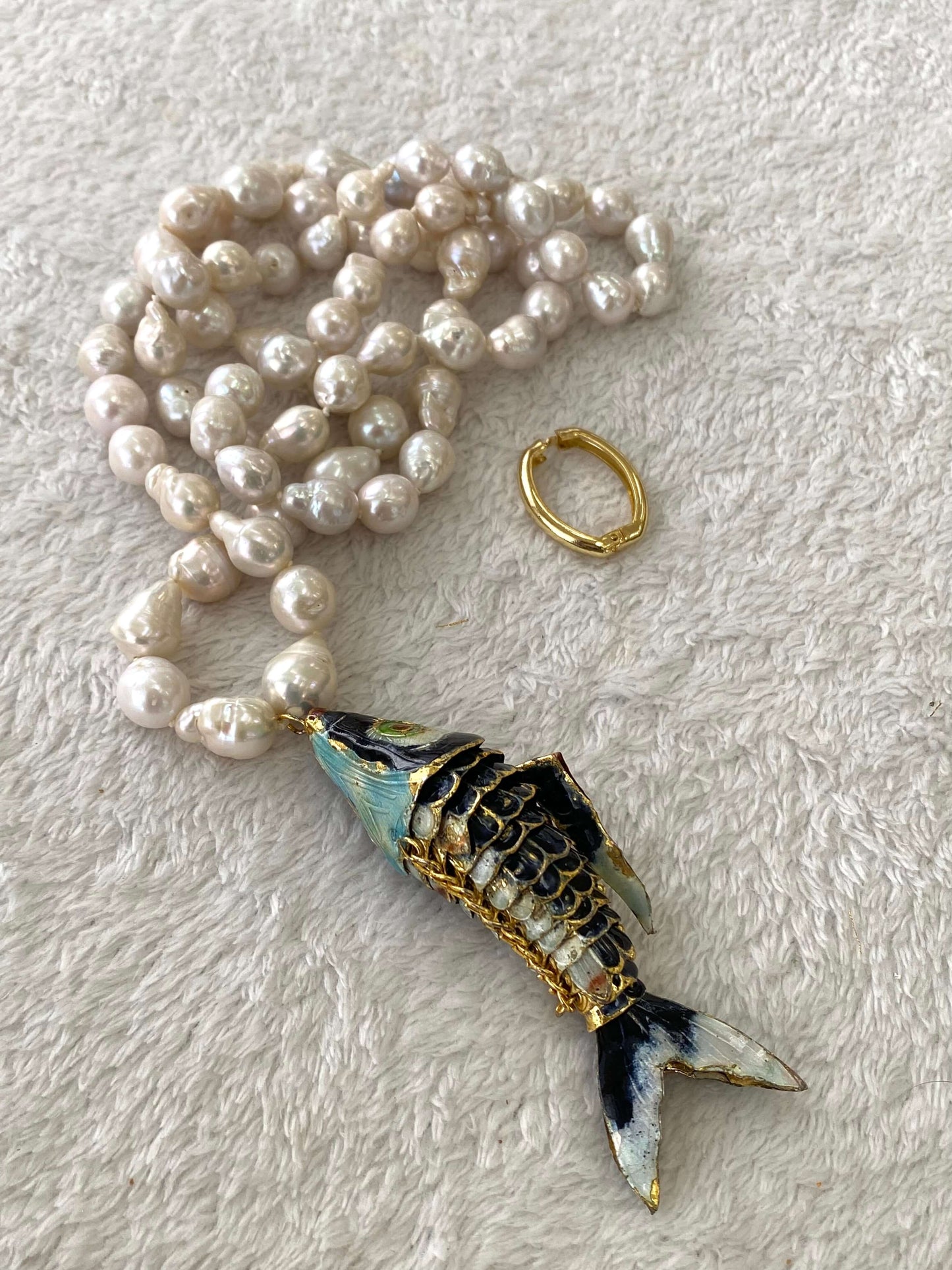 Fish pendant pearl necklace featuring a cloisonné fish pendant and hand knotted baroque pearls.