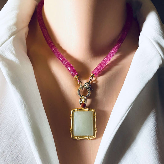 Bamboo style jade pendant with red agate in gold vermeil showcased on a model's neck with a pink necklace.