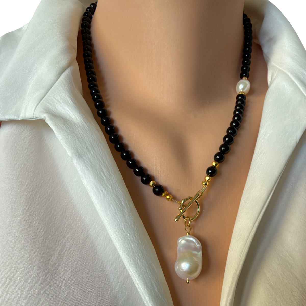 The pearl Solitaire Toggle necklace, back onyx and gold coated pyrite beads, finished with a gold plated toggle clasp and a beautiful white baroque pearl pendant 19-20 inches