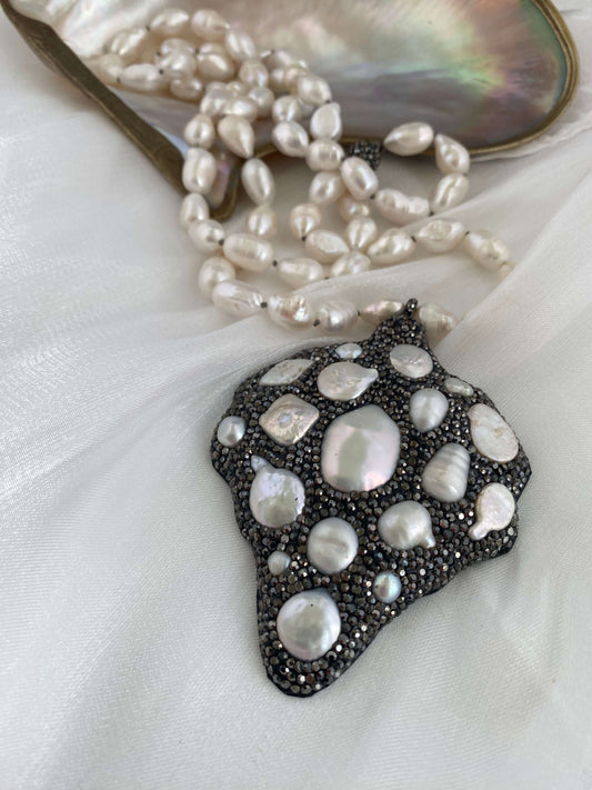 Pearl necklace and pendant on a white fabric background