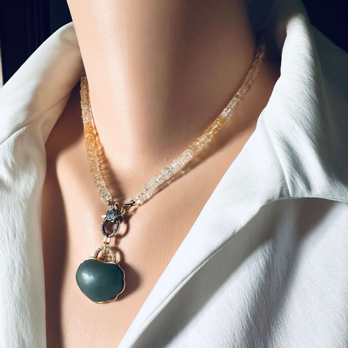 Shaded citrine gemstone necklace with a diamond pavé gold vermeil clasp worn on a mannequin.