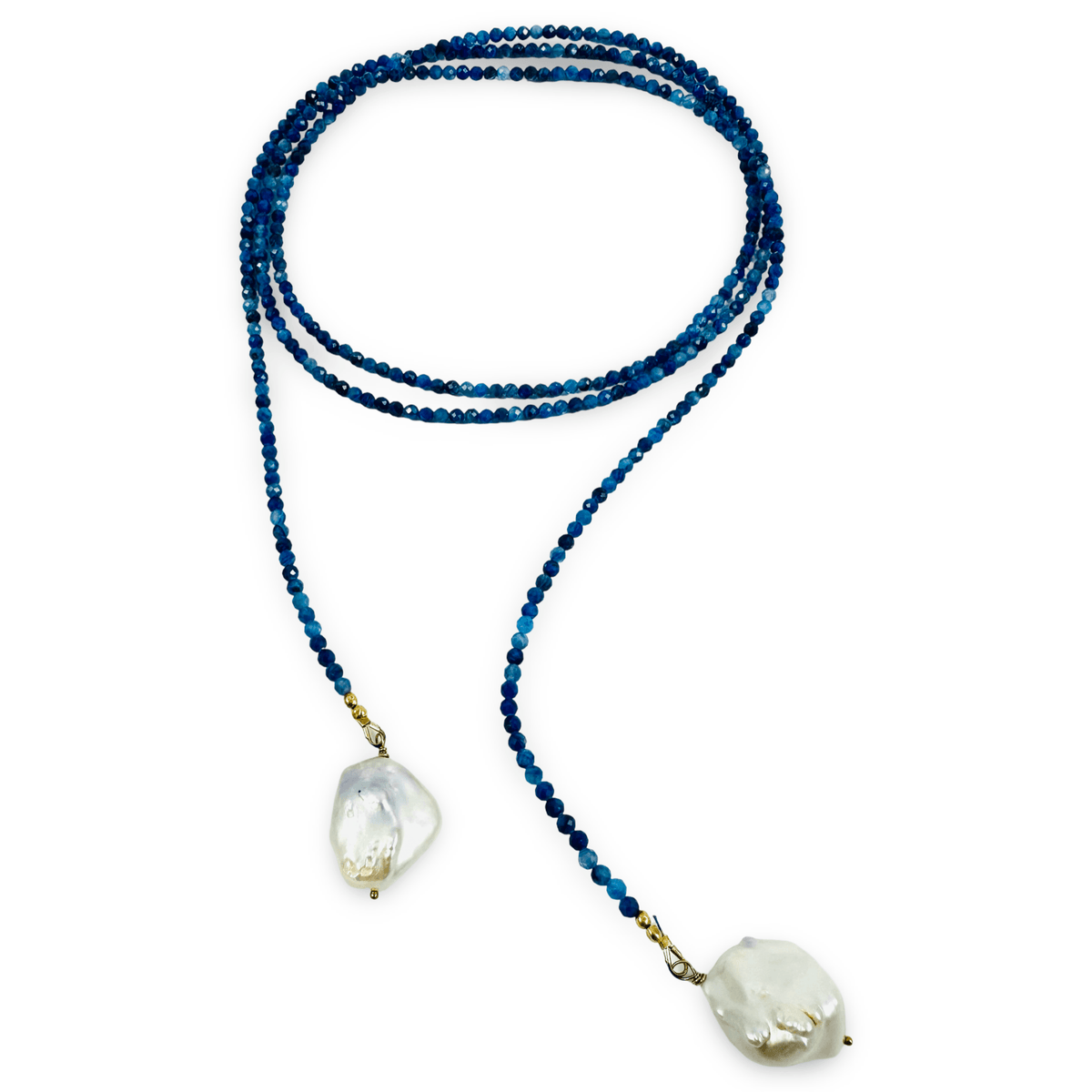 A beaded necklace featuring dark blue faceted beads and two large, irregular white mother-of-pearl drop pendants, displayed on a clean white background.