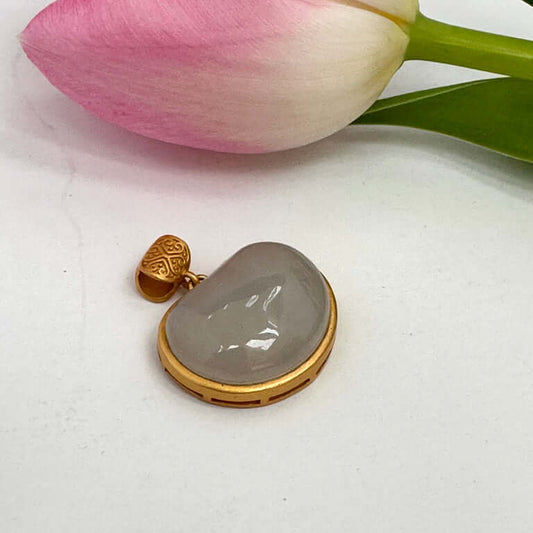 Hotan jade charm pendant in gold bezel featuring natural nephrite jade with a smooth teardrop shape and pink tulip.