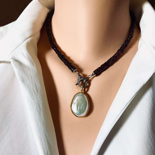Baroque pearl pendant in gold vermeil with double-sided pearl charm worn on a model's neck.