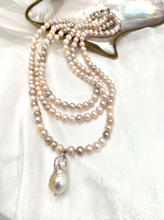 Pearl necklace with a pendant on a white fabric background
