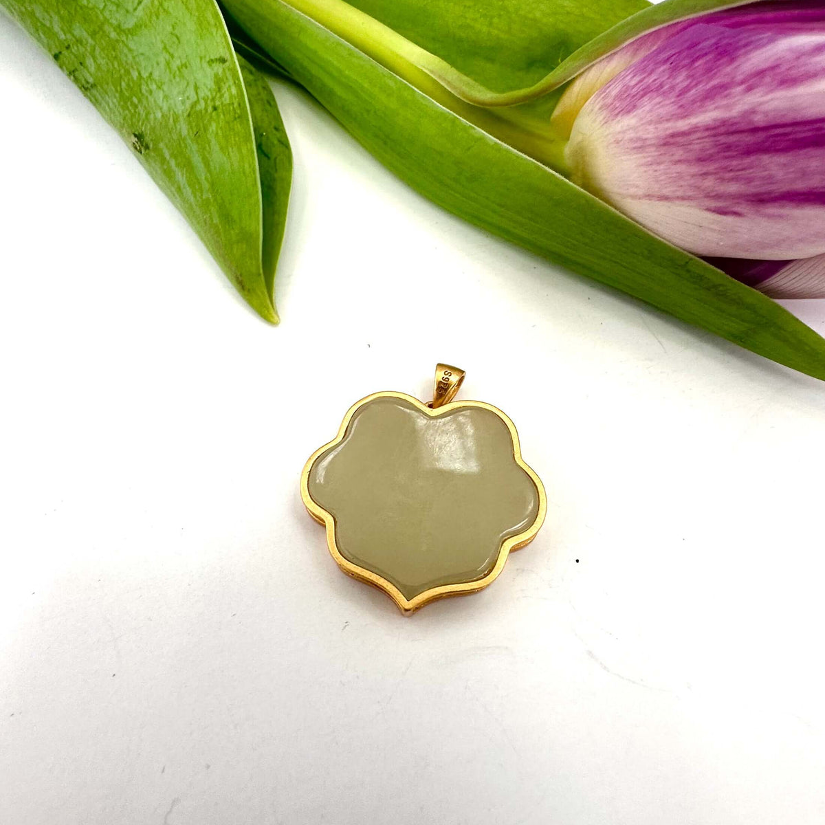 Hotan jade pendant in gold vermeil showcasing polished nephrite charm with floral-inspired silhouette.