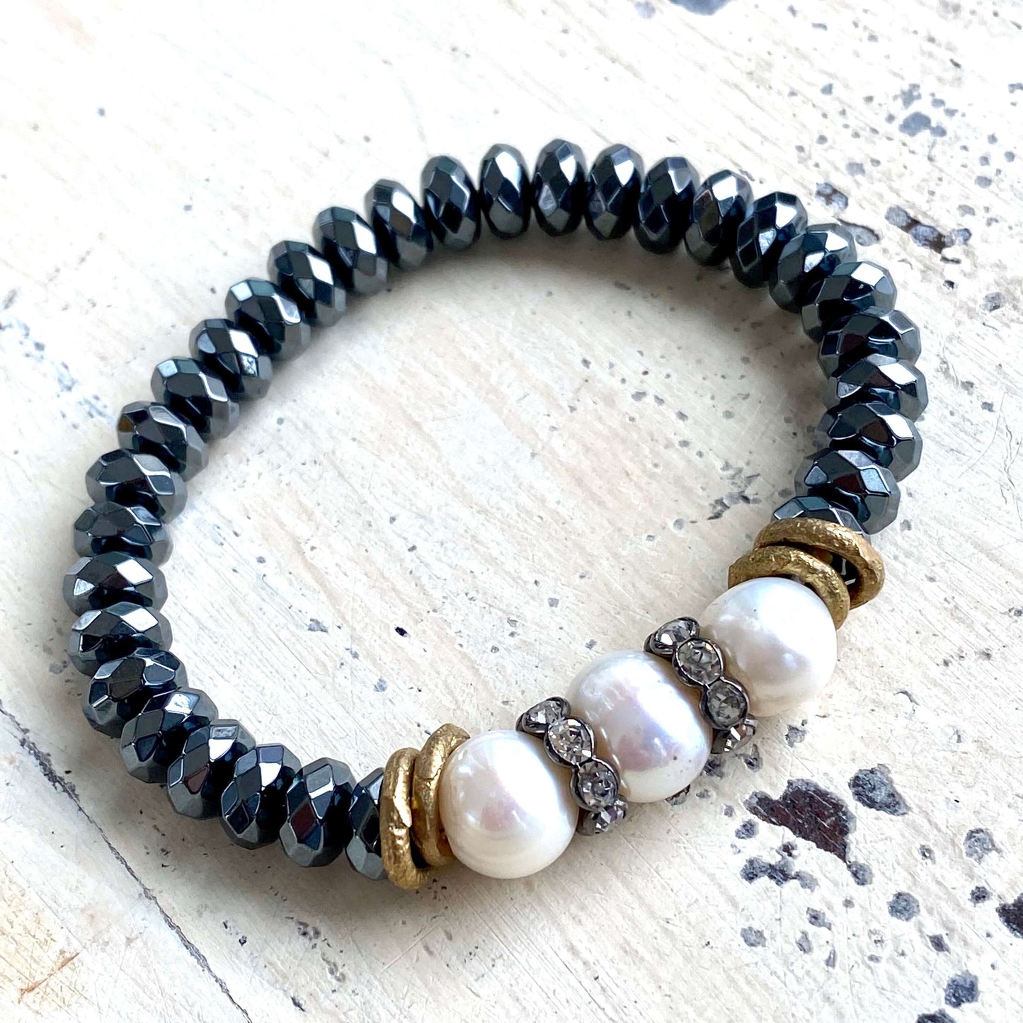 Freshwater pearl hematite stretch bracelet detailed view of circled pearl surface and dark beads